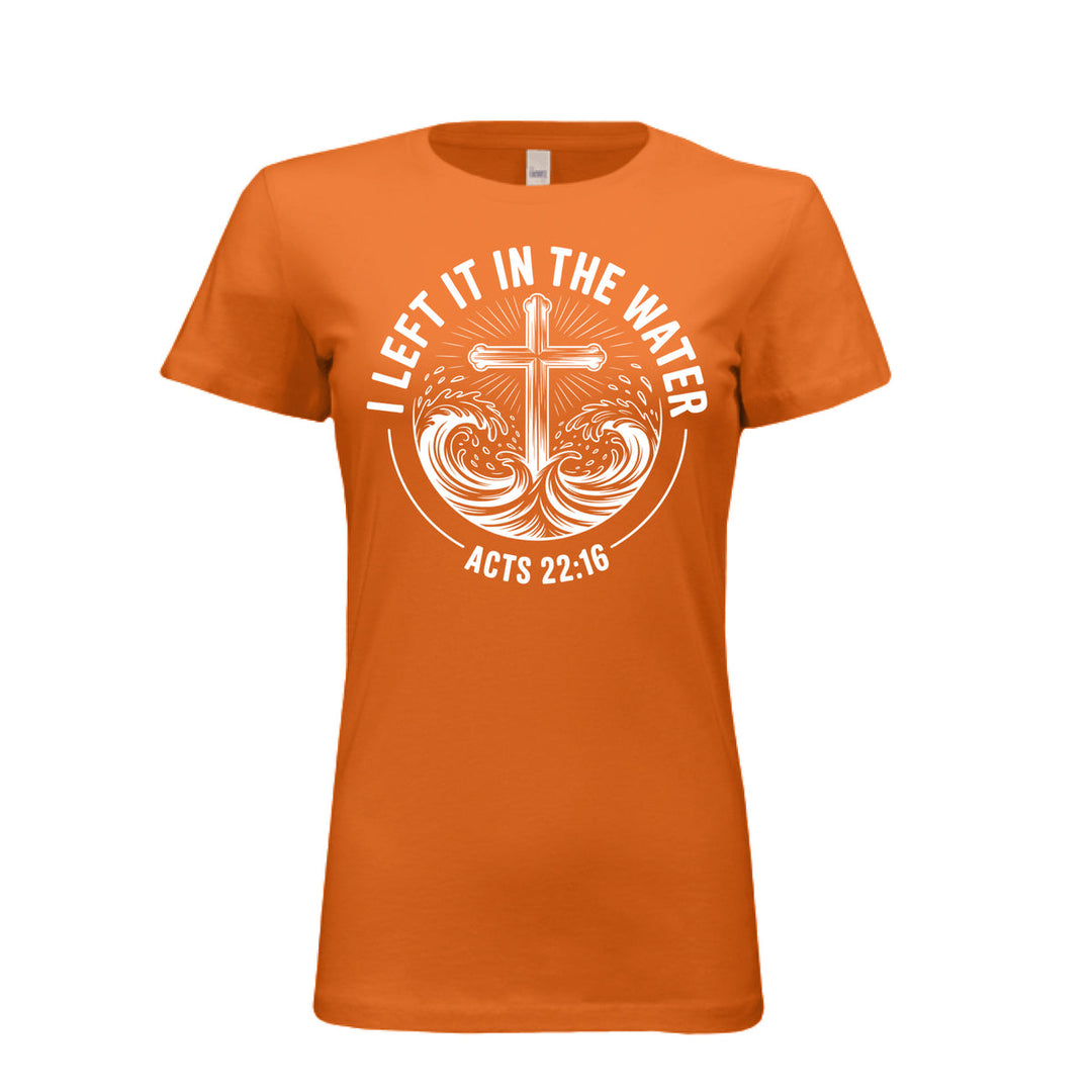 Women's fitted orange tee featuring a white cross rising from stylized waves with the words “I Left It in the Water – Acts 22:16” in bold curved text