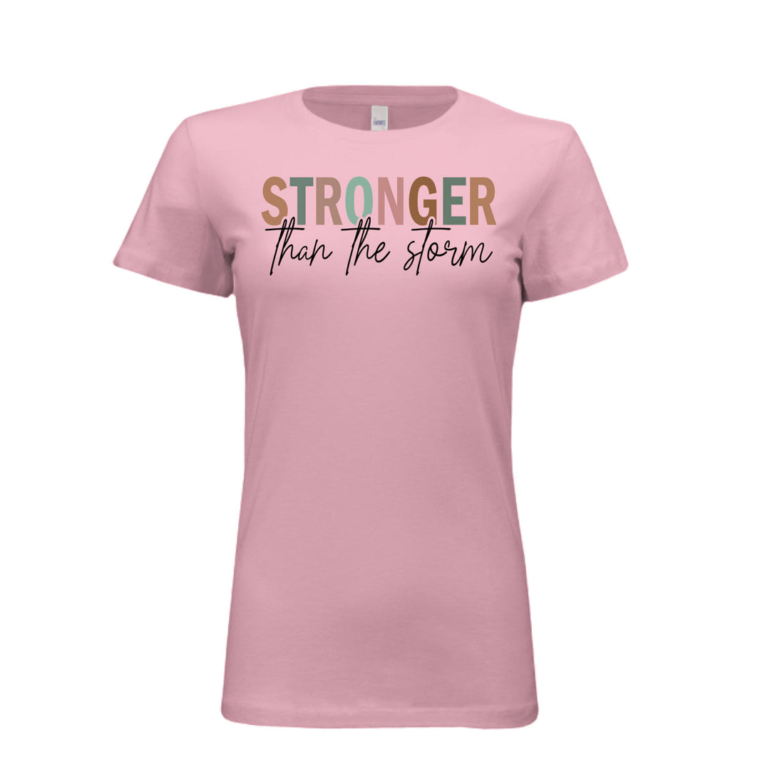 Women's fitted tee in pink with bold multi-color “STRONGER” and black script “than the storm” across the chest.